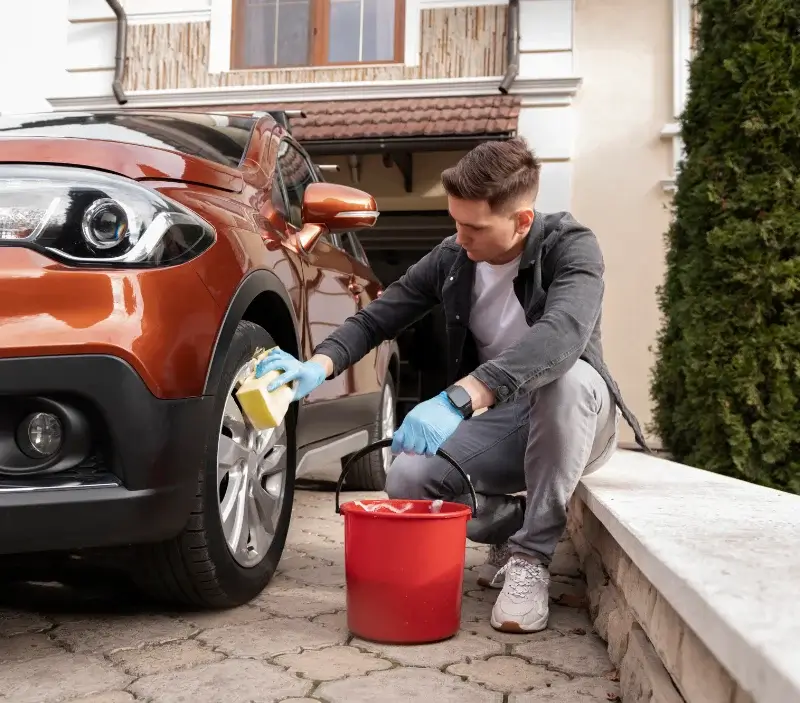 Lavage auto à domicile Saint-Georges-du-Bois : professionnel intervenant sur un véhicule
